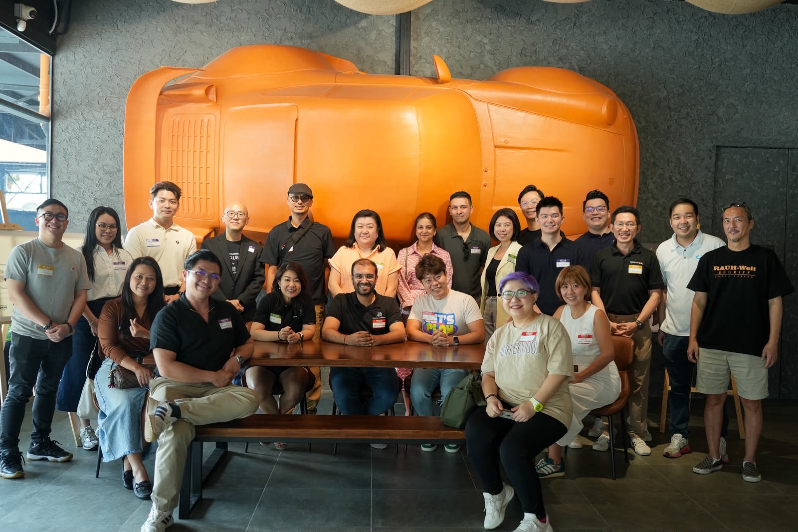 Payments Club members at a meetup in front of a giant orange car sculpture